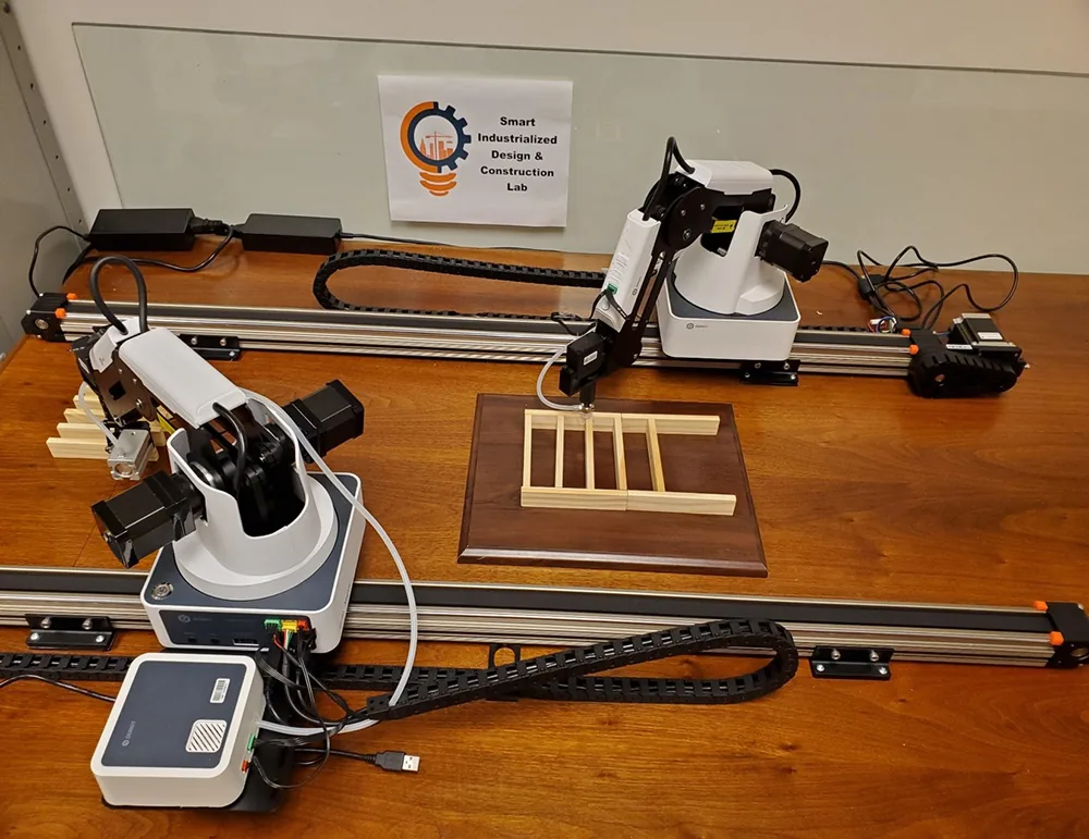 Dos robots de mesa diseñados para armar maquetas de muros de edificios