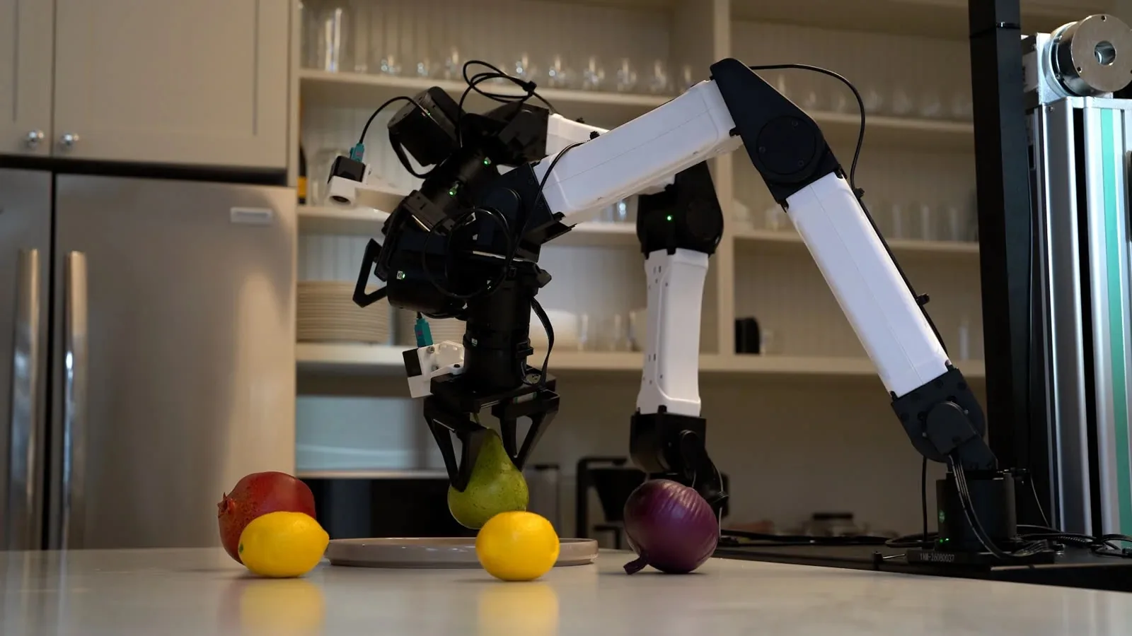 Dos brazos robóticos de Runway AI recogen fruta en una cocina