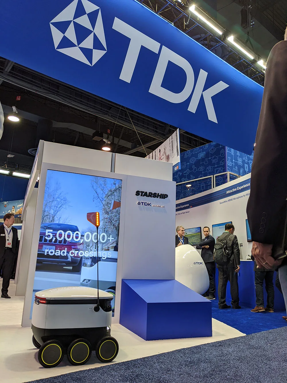 Stand de TDK Ventures en una feria, con un robot de Starship