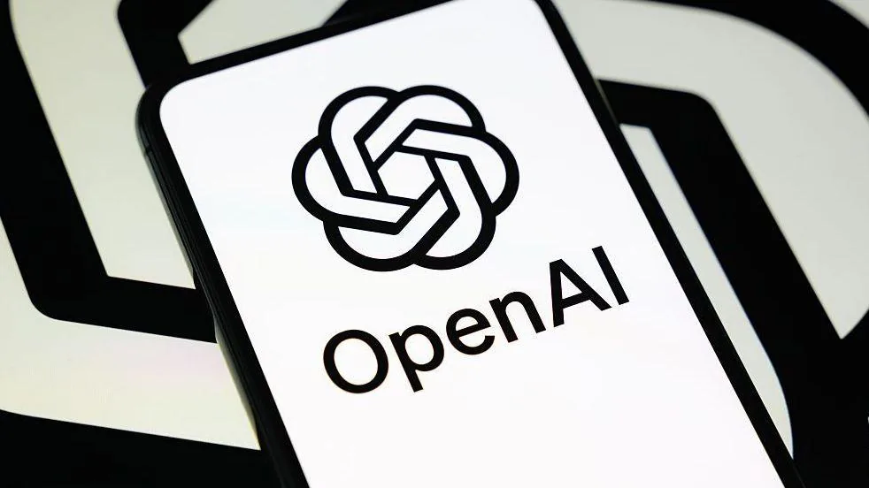 El logo de OpenAI en blanco y negro en un celular, sobre un fondo de espiral en blanco y negro como su logo
